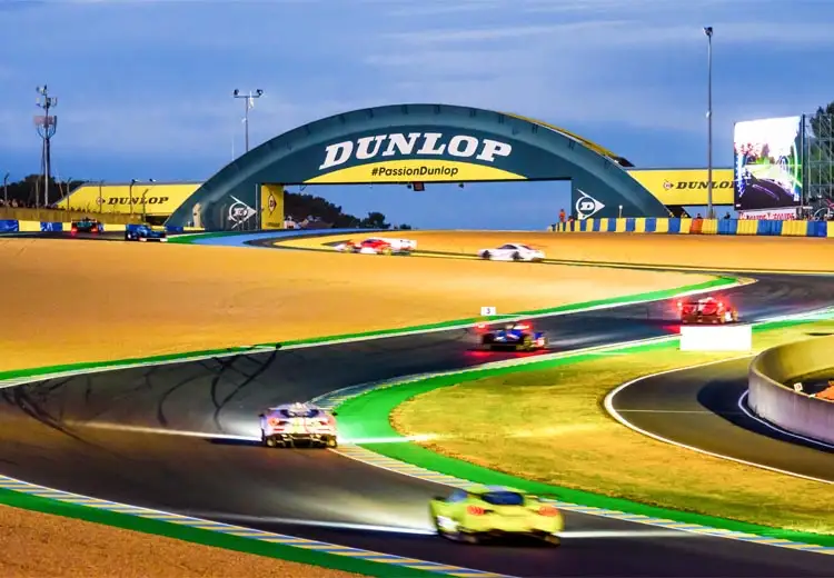 Vue artistique du circuit des 24 heures du Mans de nuit avec des voitures